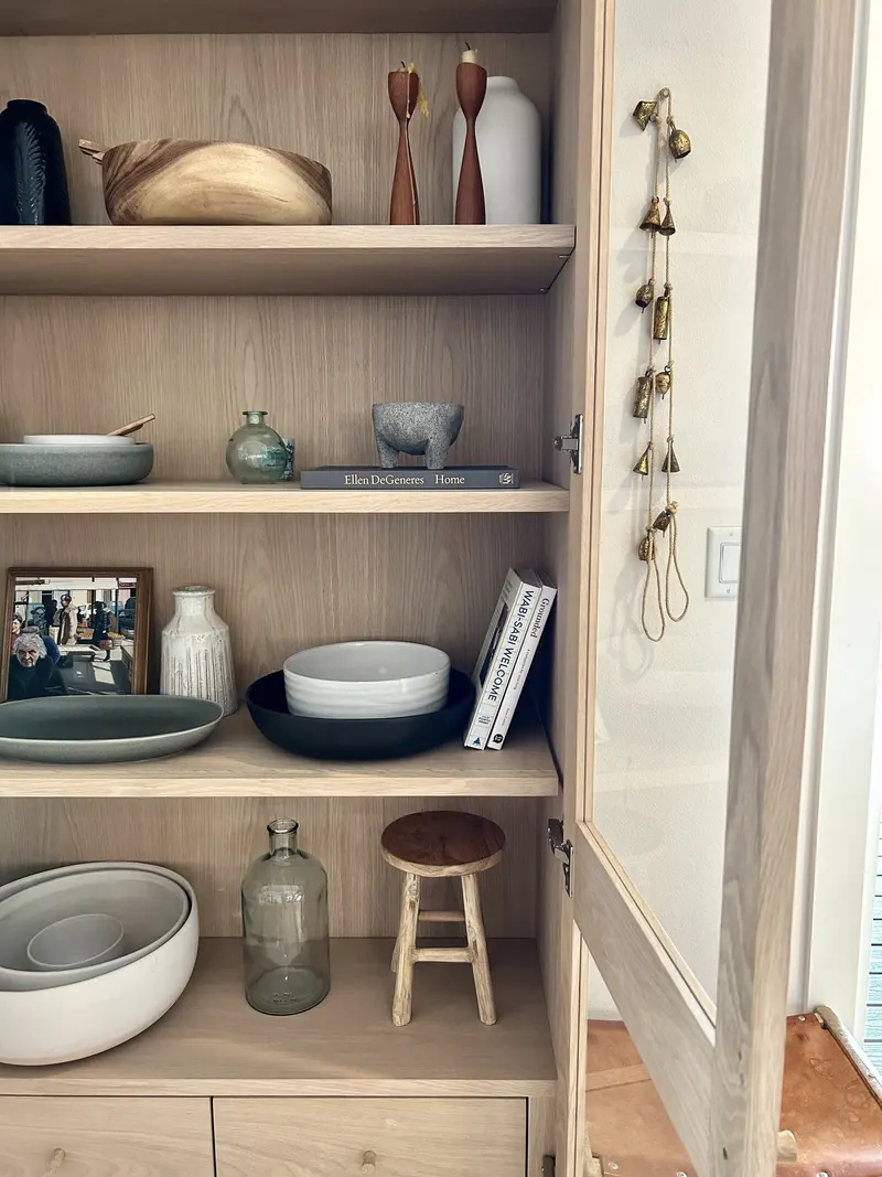 Built-in wood shelves styled with bowls, vases and books